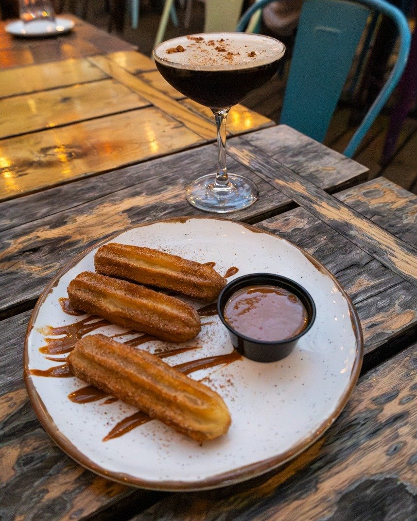 Happy National Dessert Day! 🎉 
You know what that means: treat yourself! We're celebrating with sweet temptations like these delicious churros. Want to keep the party going? Sip on a perfectly chilled Espresso Martini, or go big with our $20 Margari