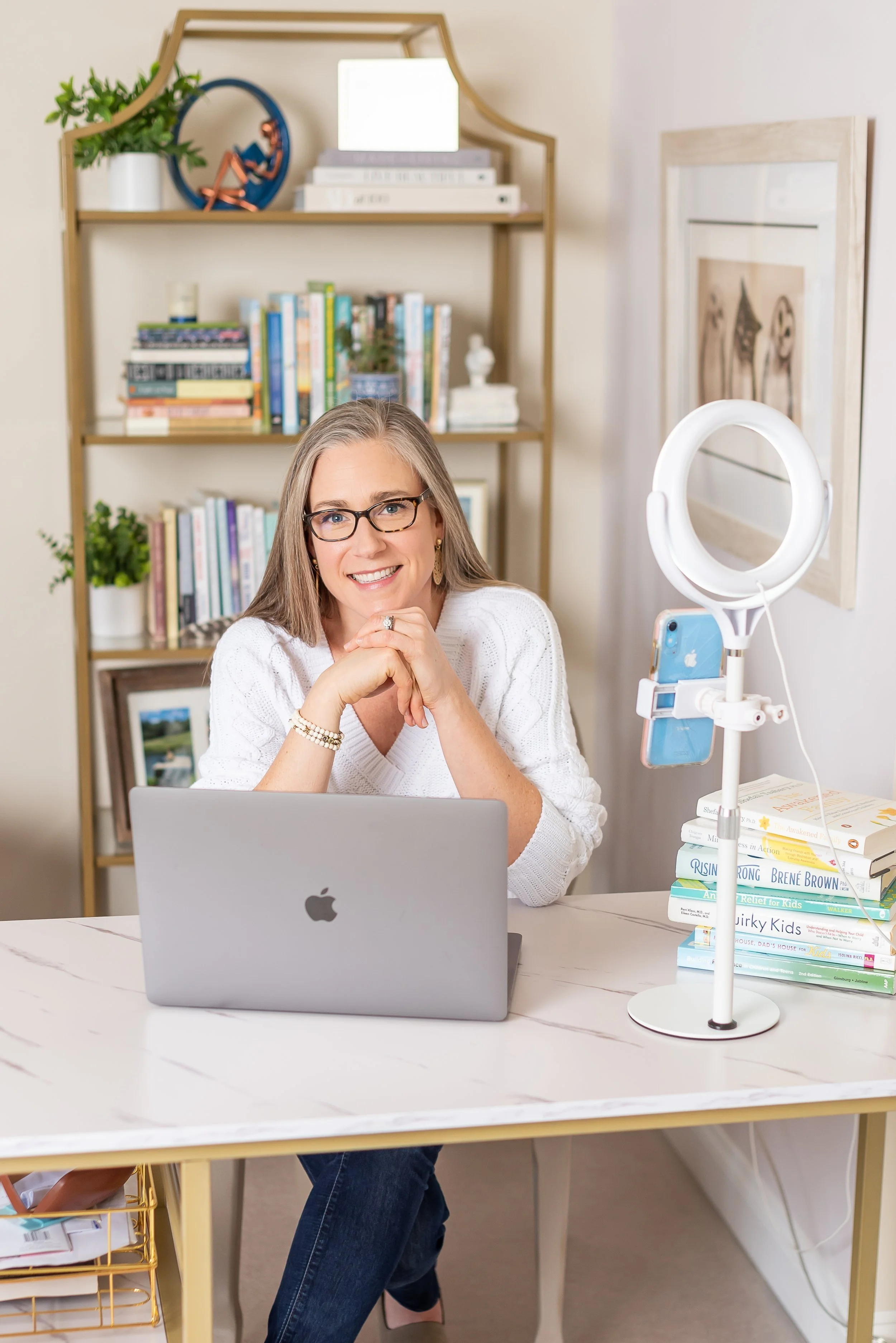 Dr. Meghan Hulver in her virtual work space smiling over her computer at the camera
