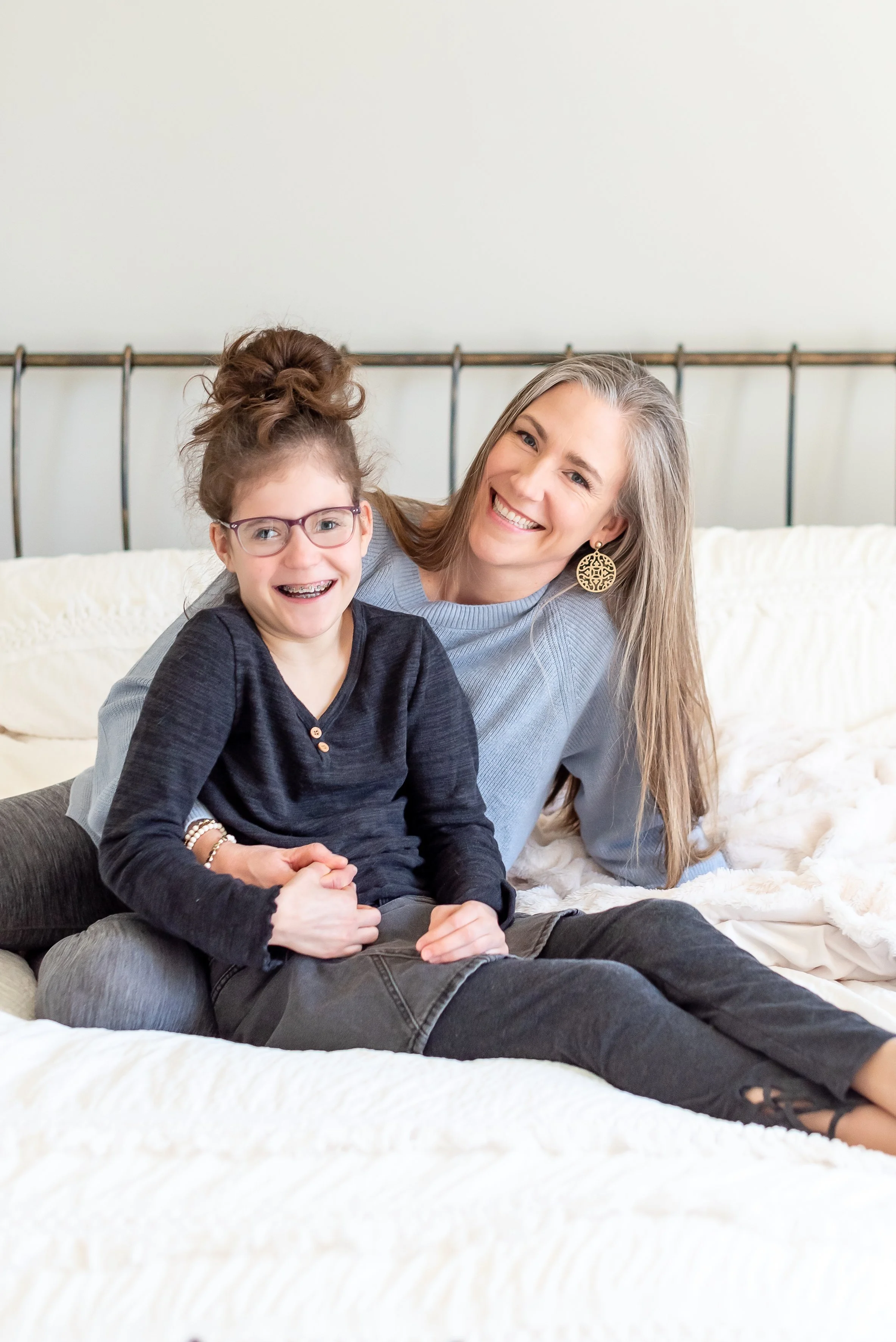 Dr. Meghan Hulver and her daughter laughing on a bed