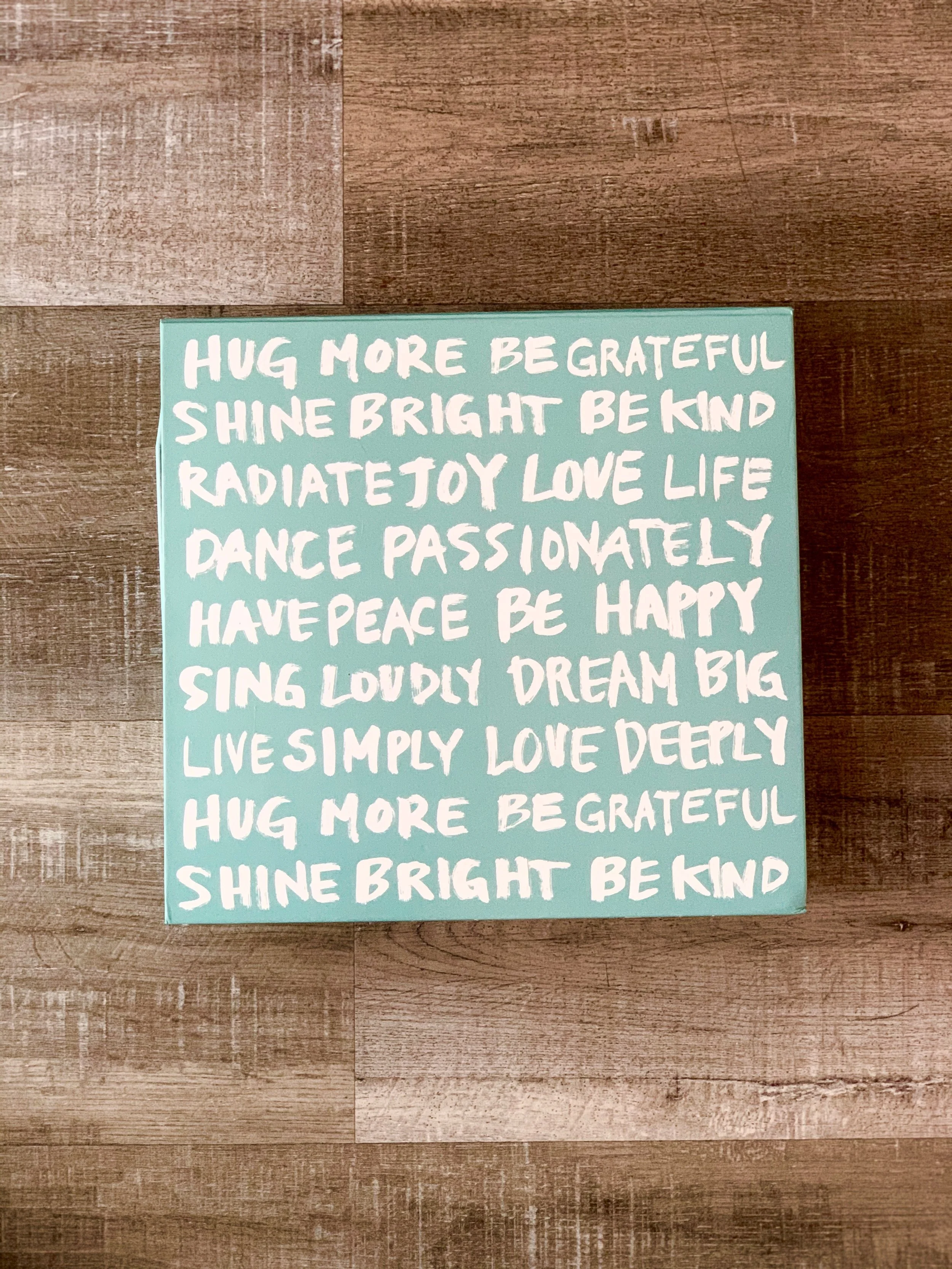 Inspirational quote on blue wooden placard with a wood background
