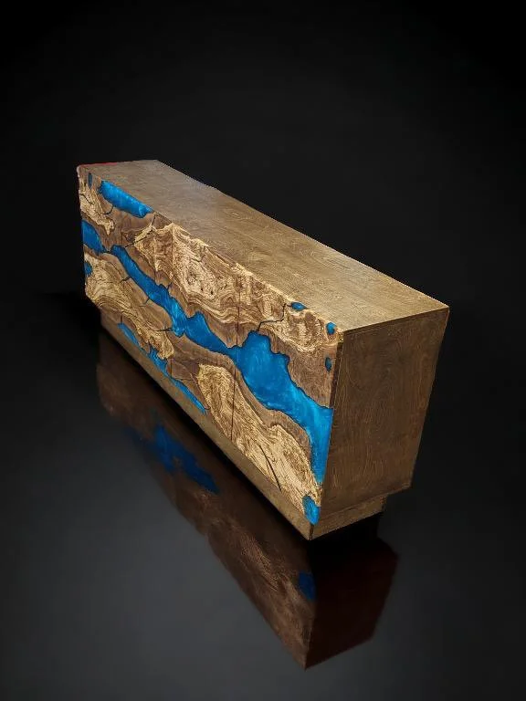 Wood and resin console table with blue inlays, set on a dark reflective surface.