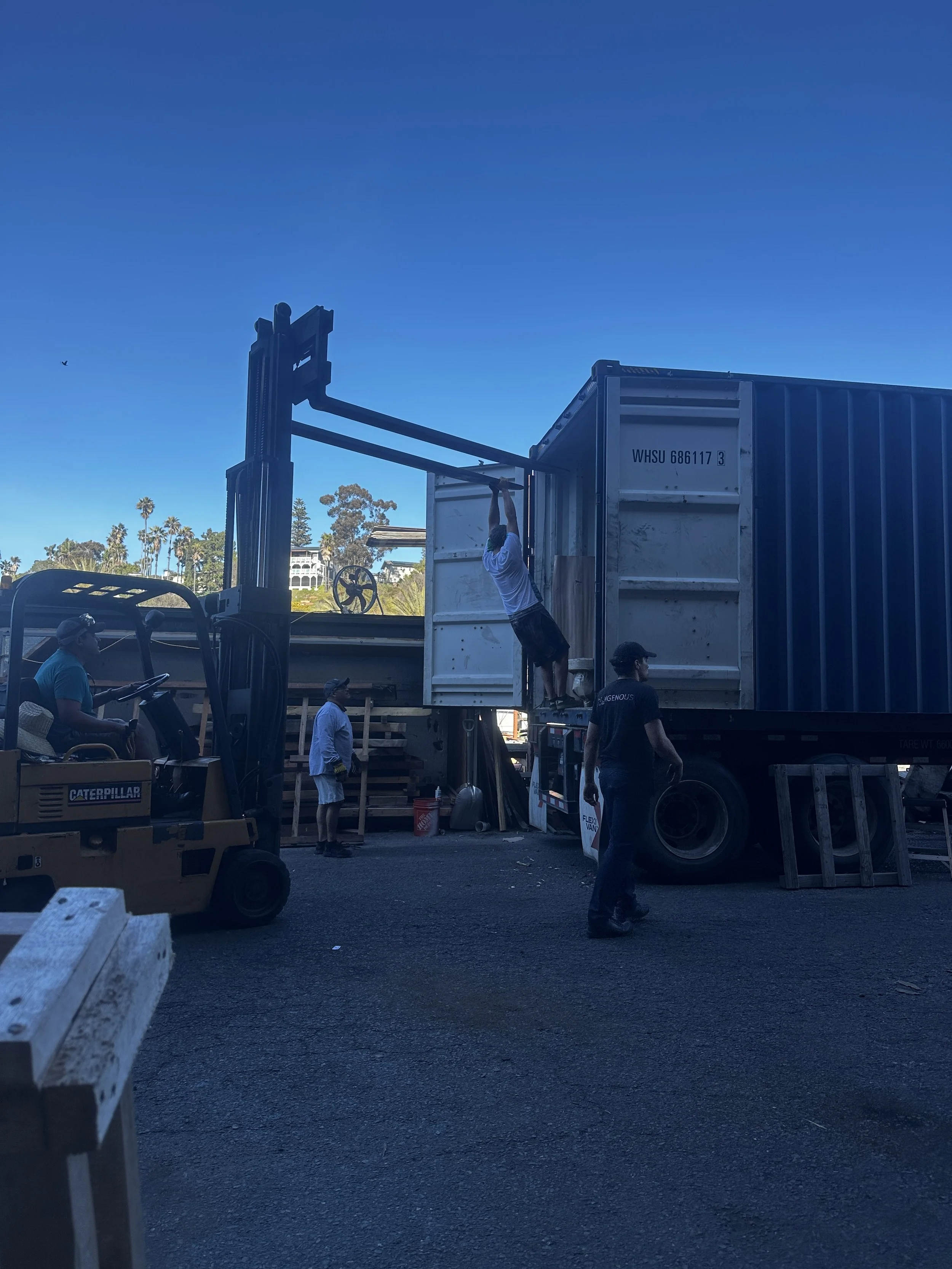 Indigenous by la rue team loading a shipping container with a forklift for worldwide delivery of custom live edge wood furniture