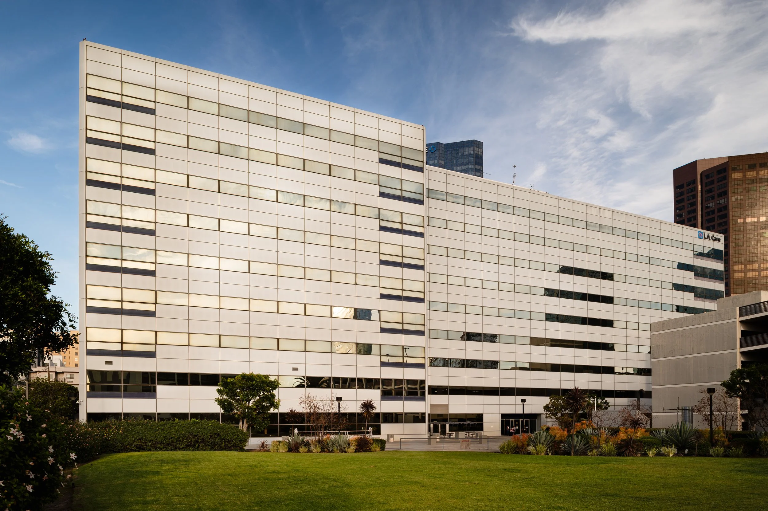 Modern corporate office building exterior with glass facade and landscaped entrance in Los Angeles, professional architectural photography by Gavin Haag
