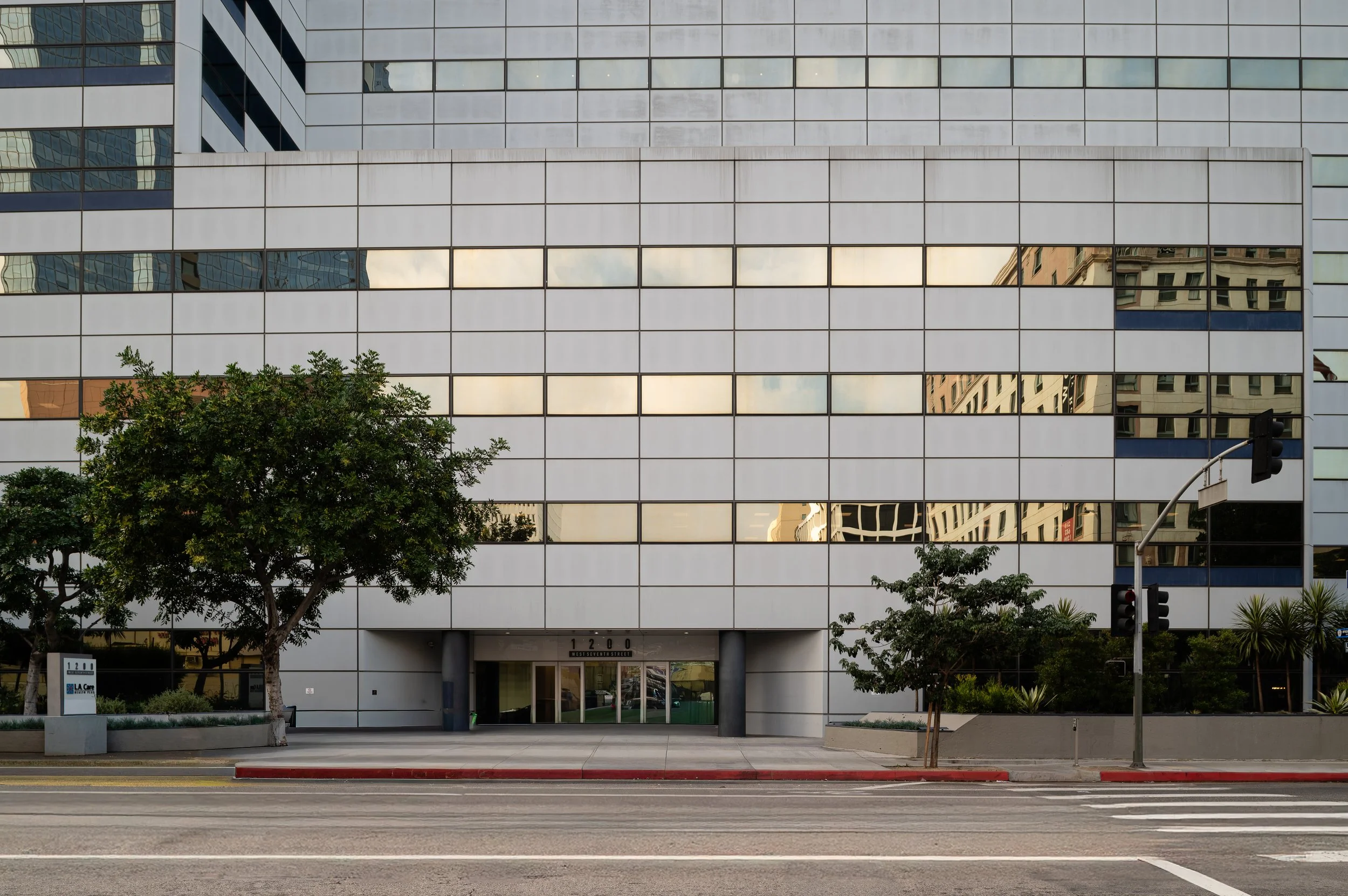 Contemporary white office building with green landscaping, architectural photography showcasing urban design and commercial real estate in Los Angeles
