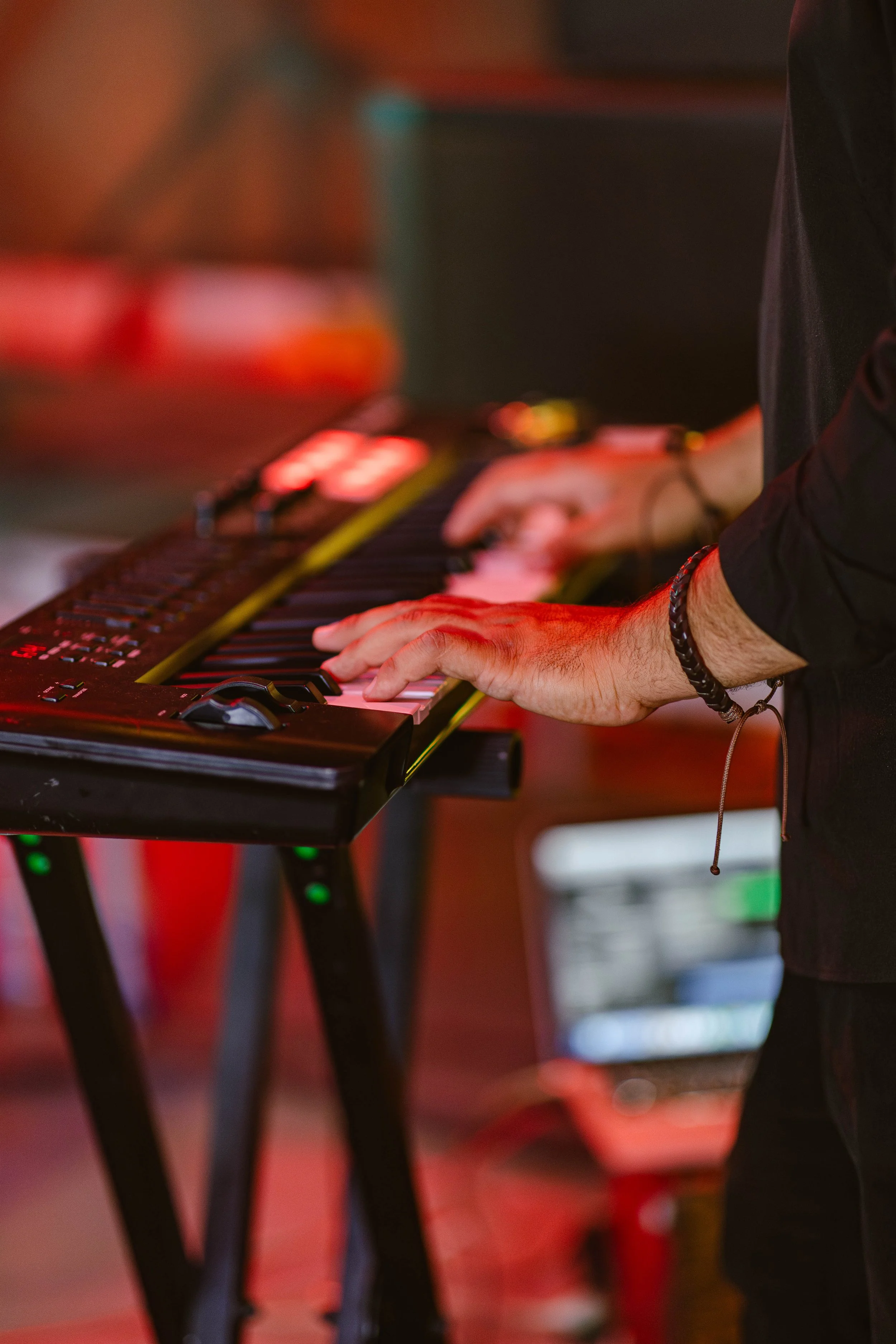 Person playing a keyboard on a stand during a performance.