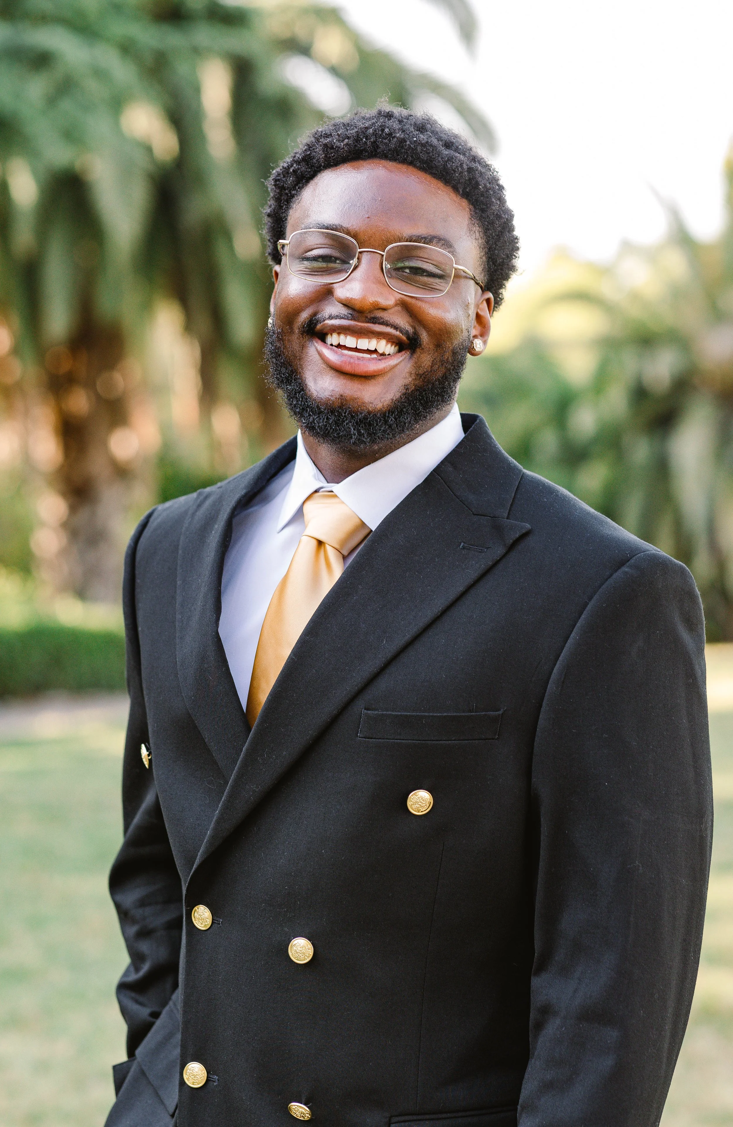 College graduate walks along the grass during portrait session at Avril Park in San Pedro, California.jpg