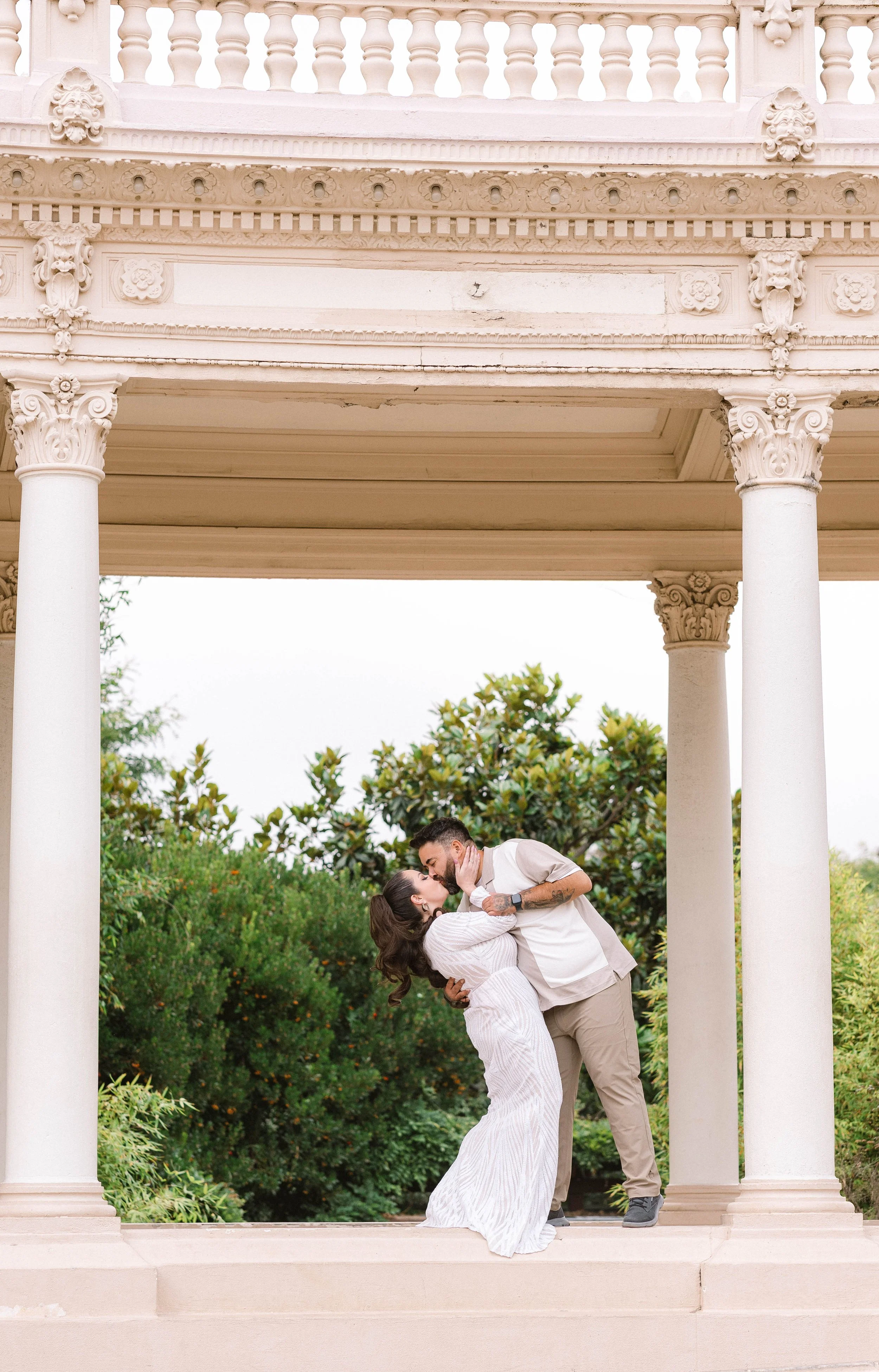 Couple kisses between ornate columns, Balboa Park, San Diego