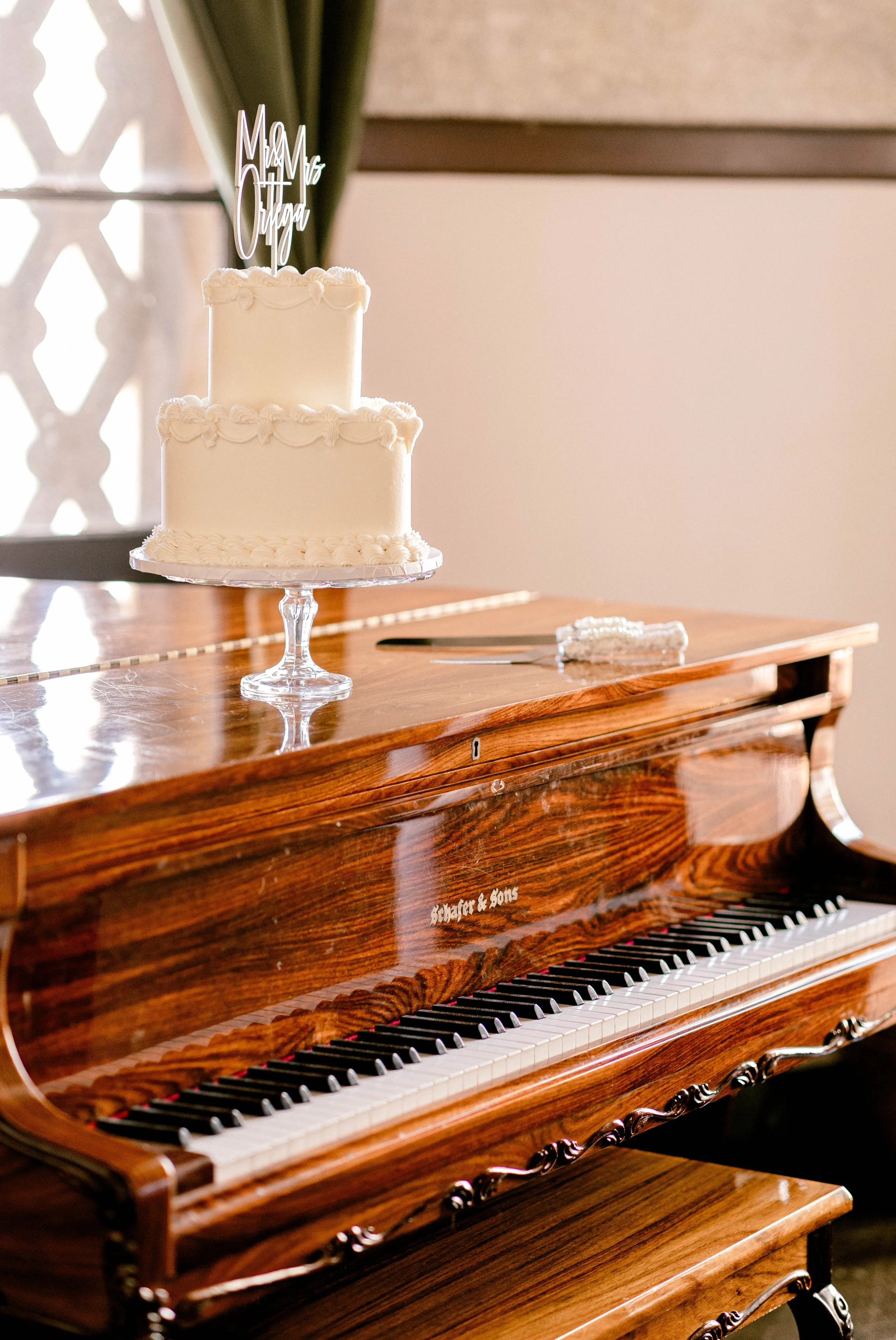Wedding cake sits on top of baby grand piano