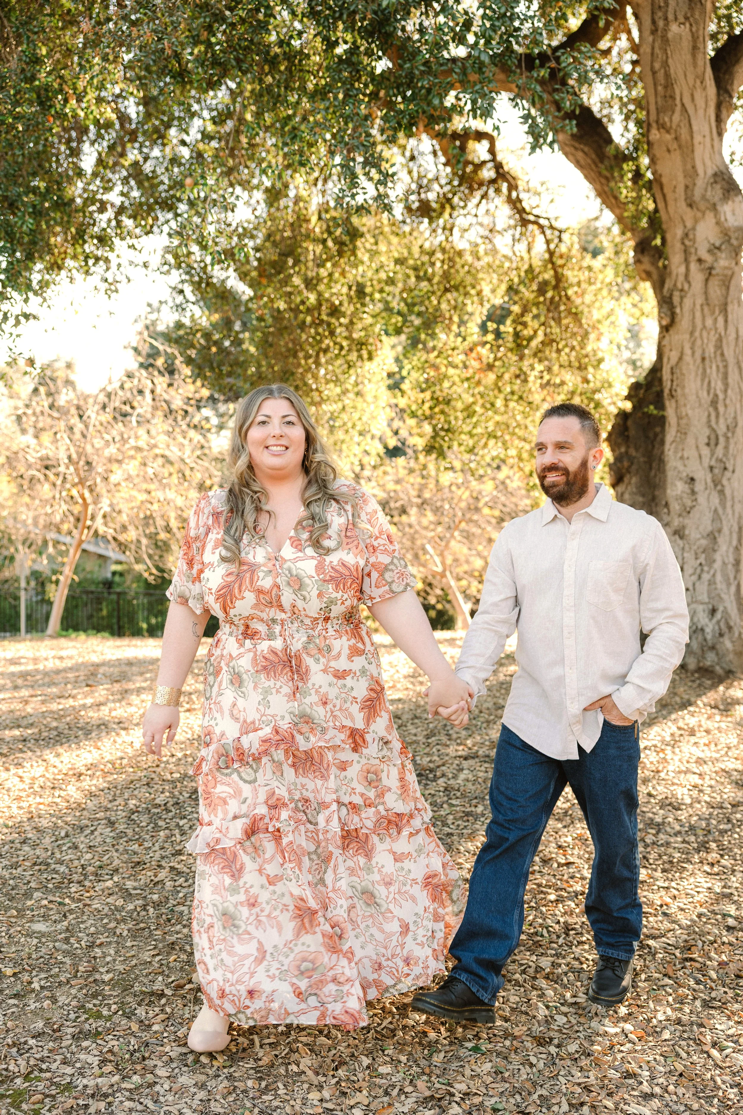 Couple walks hand in hand under a canopy of trees, Pasadena, California