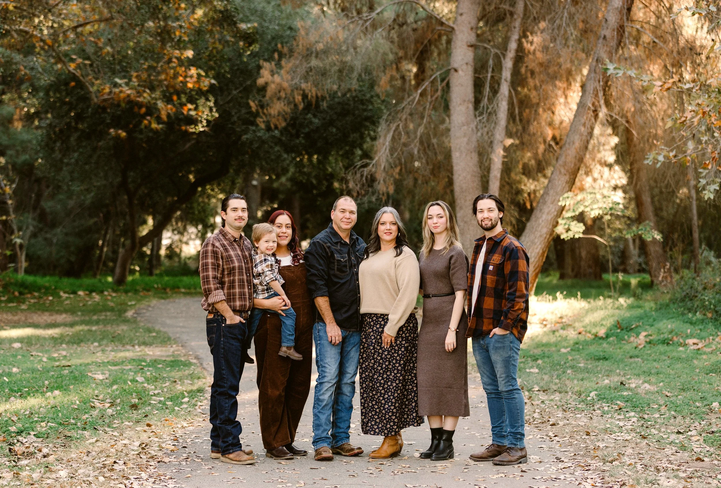 Family group stands on a path surrounded by greenery and trees