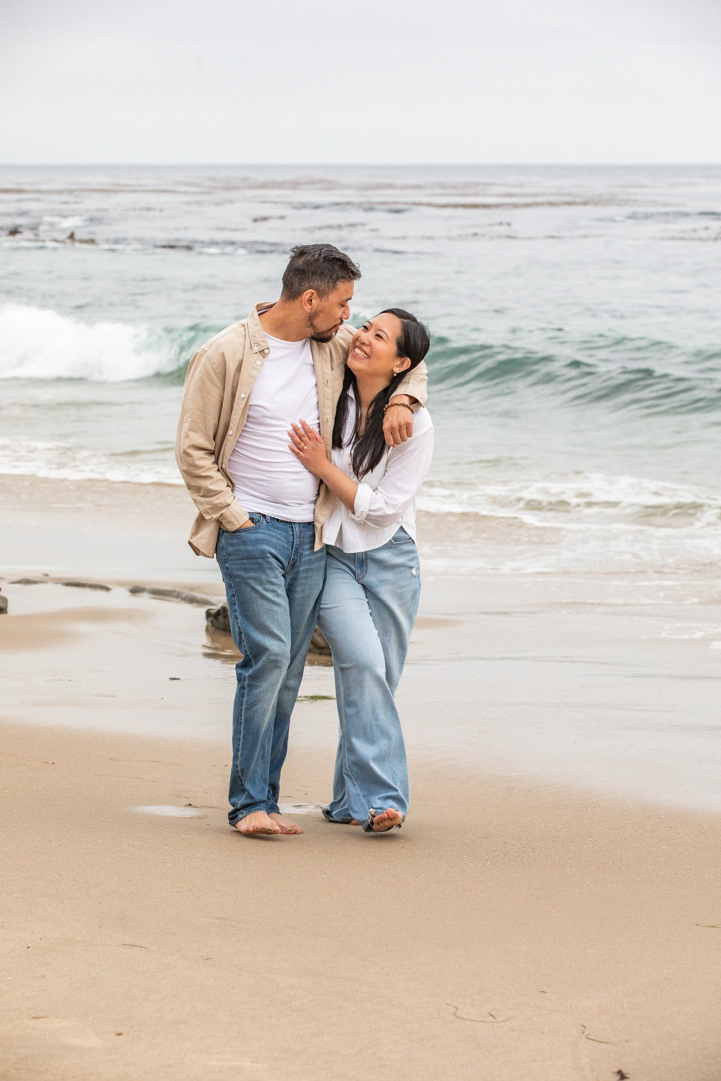 Couples walks along the beach Heisler Park Laguna Beach California