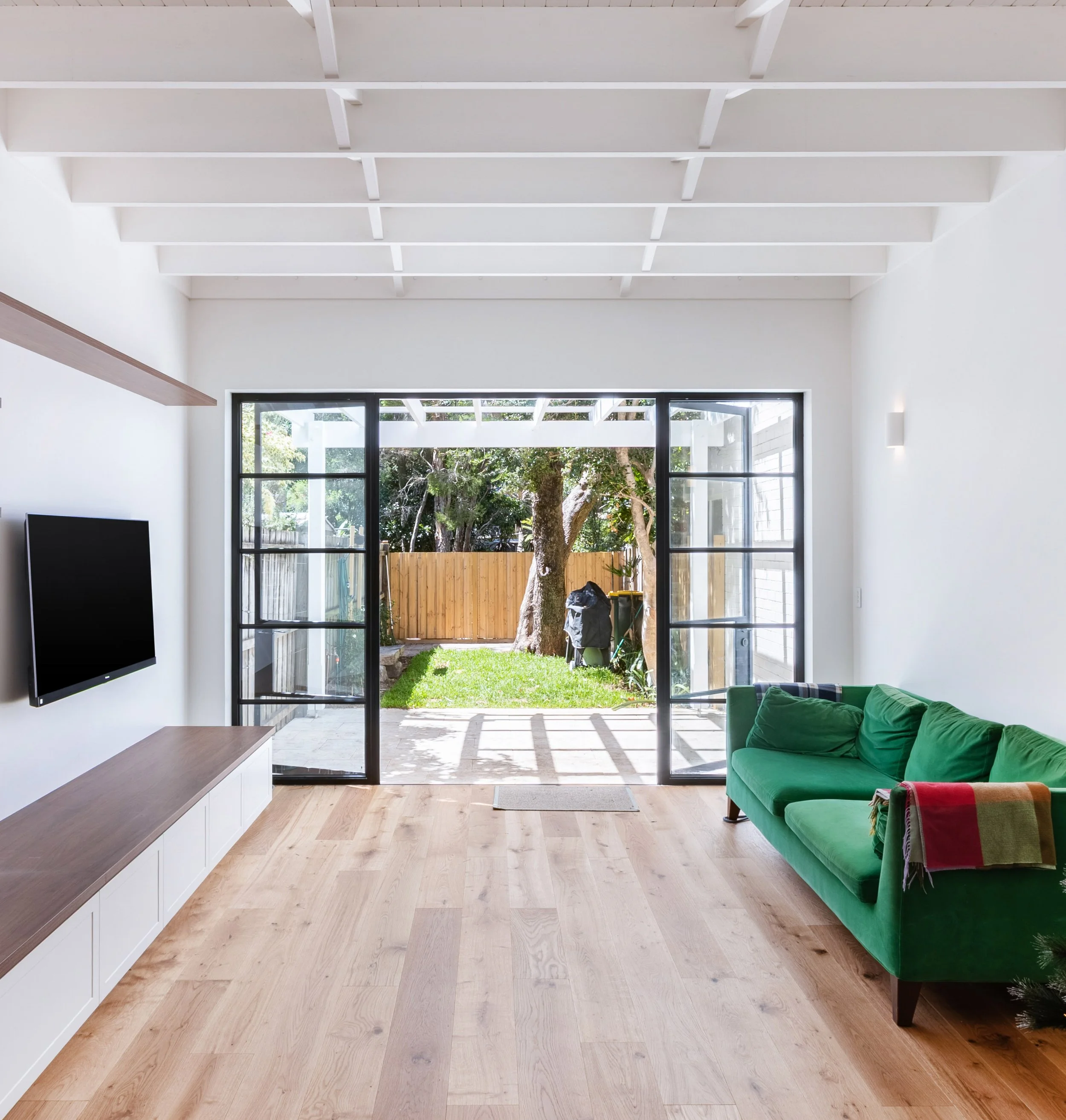 Living room with steel doors looking out onto outdoor garden
