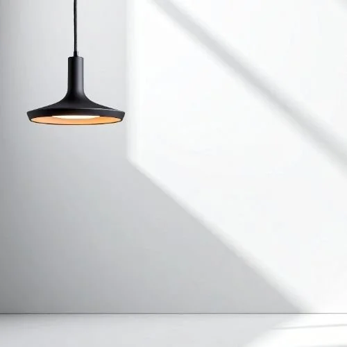 Black hanging light against a white wall in therapy office