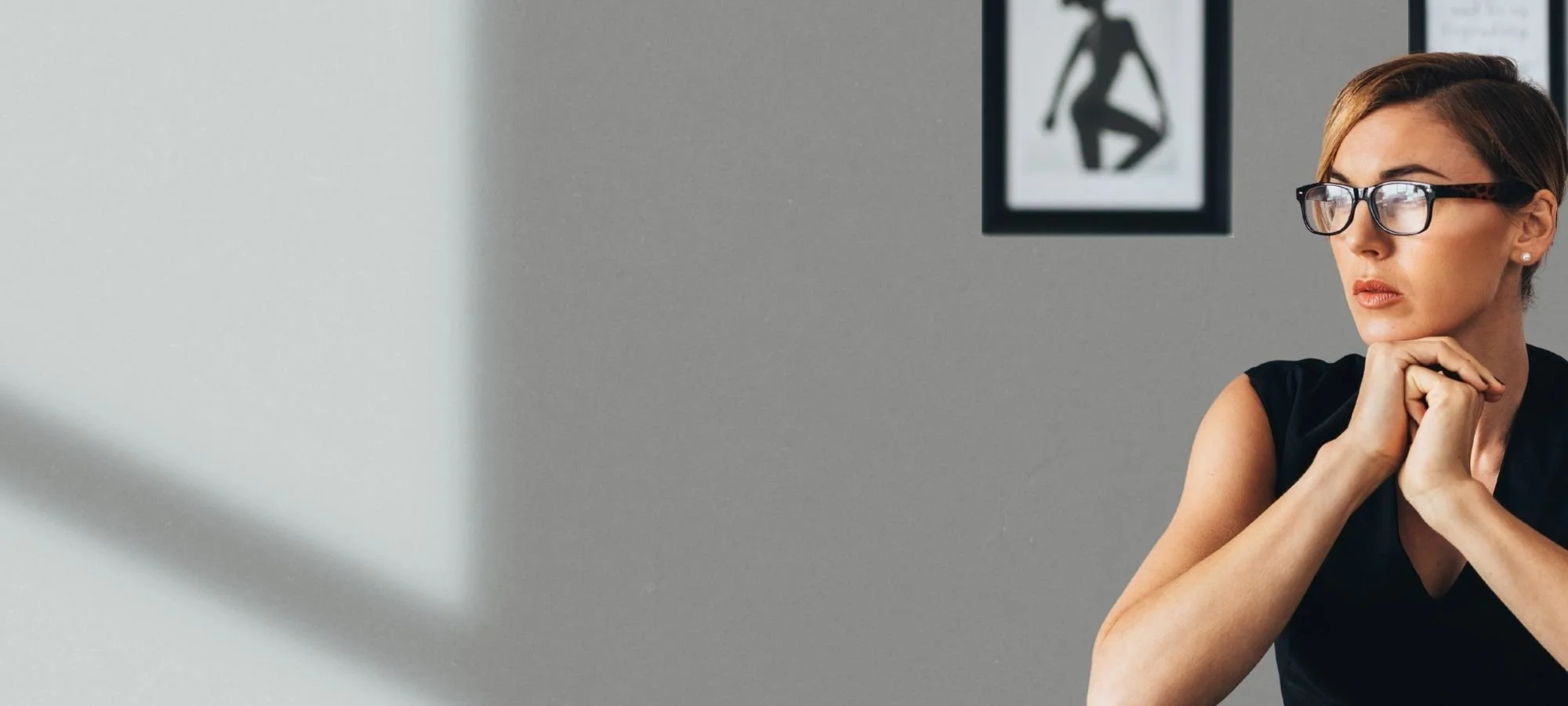 Focused professional sitting at a desk with framed art in background