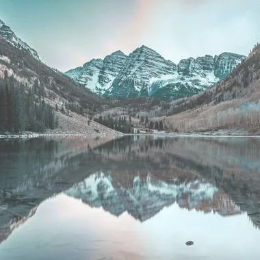 Snowcapped Colorado mountain reflected in a calm lake