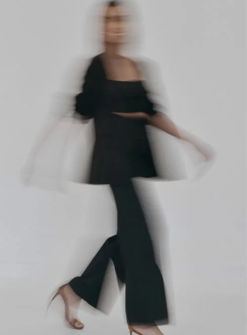 Blurred figure of a woman in black clothing walking, motion blur