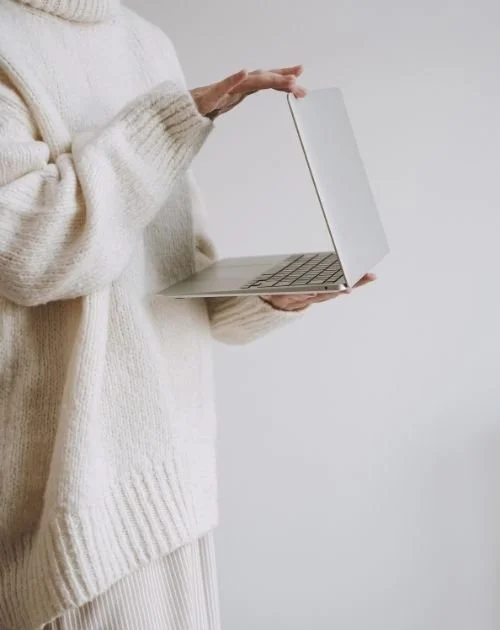 Person holding a laptop for online grief therapy