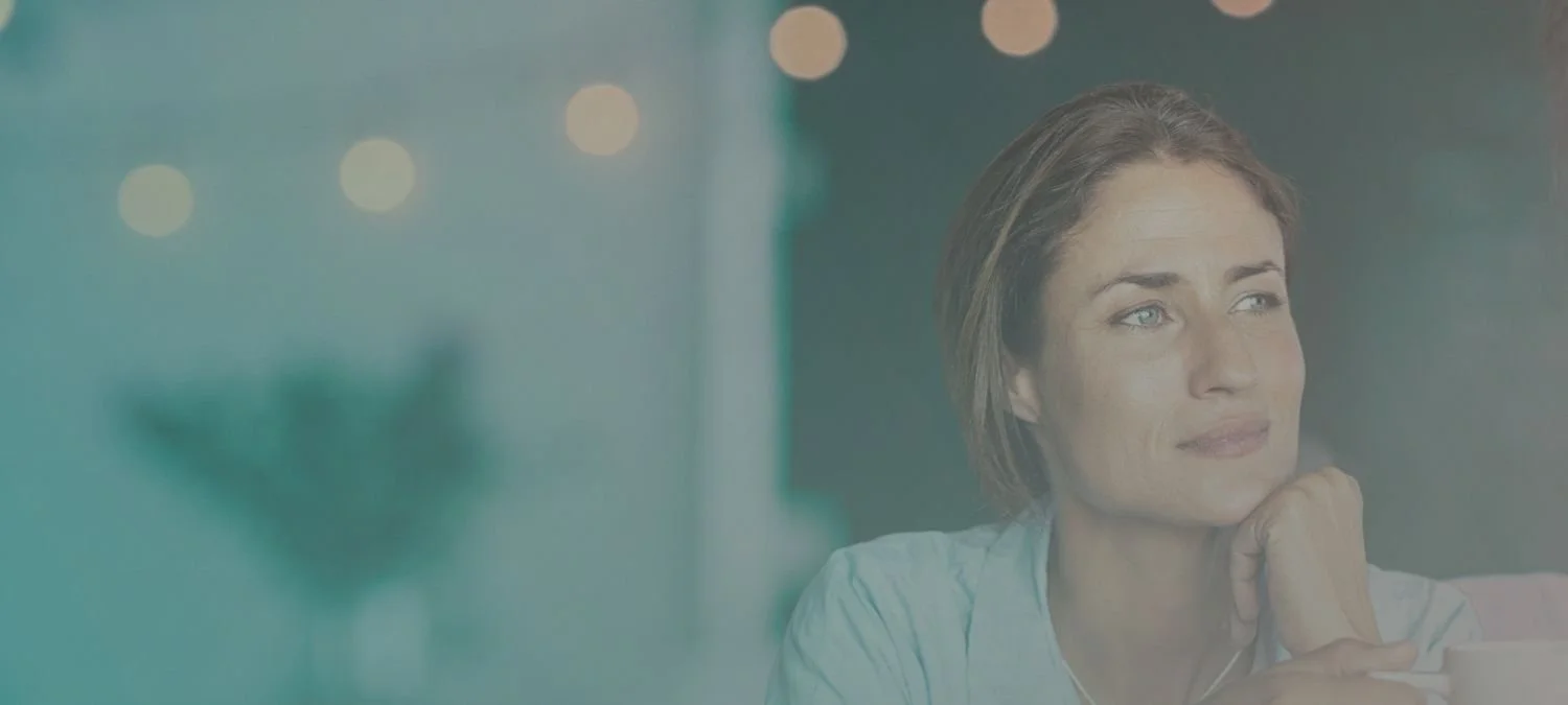 Focused female professional sitting at a coffee looking away thinking