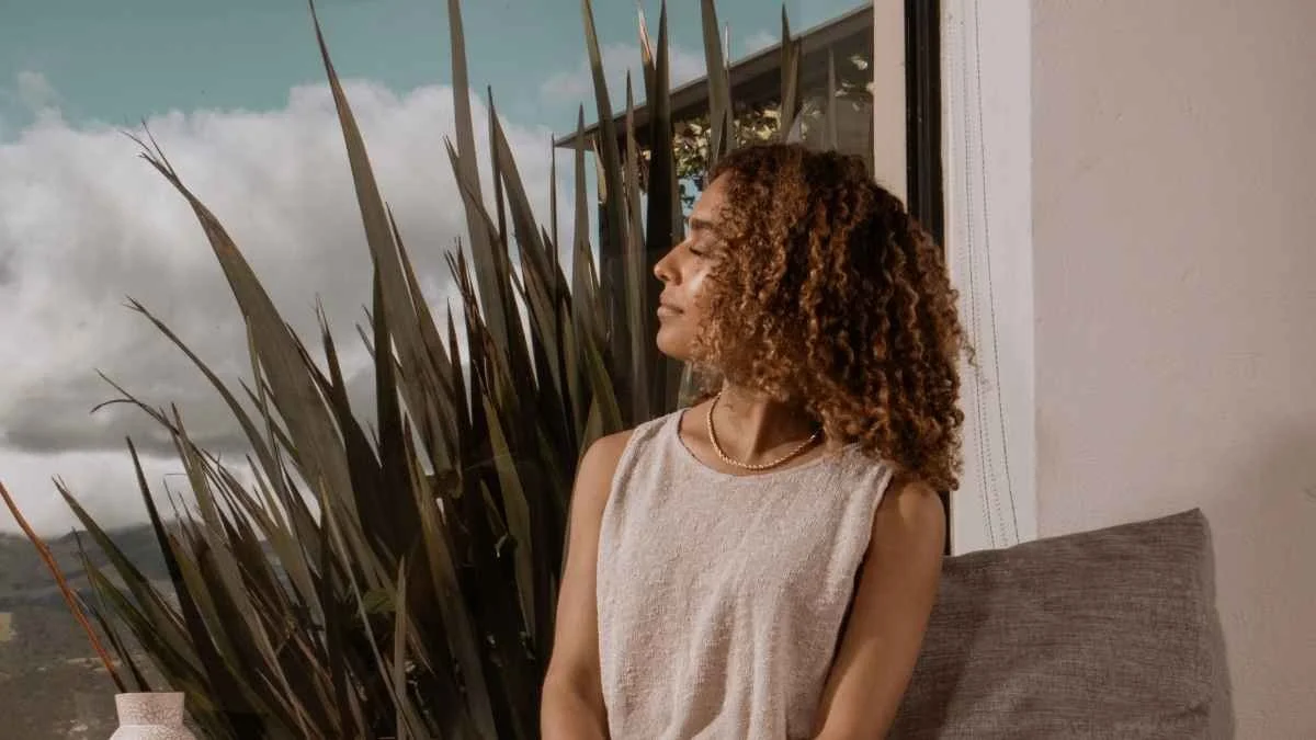 Woman standing by a window looking outside