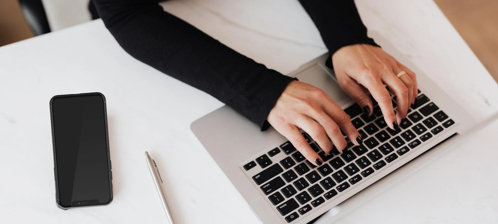 Woman's hands typing on a laptop keyboard
