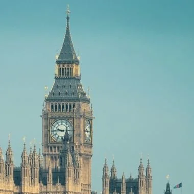 Big Ben clock tower in London against a pale blue sky