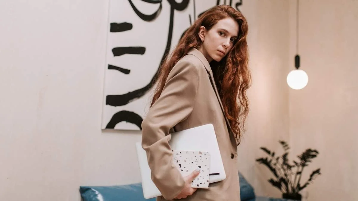 High-achieving professional woman holding a laptop during a career transition