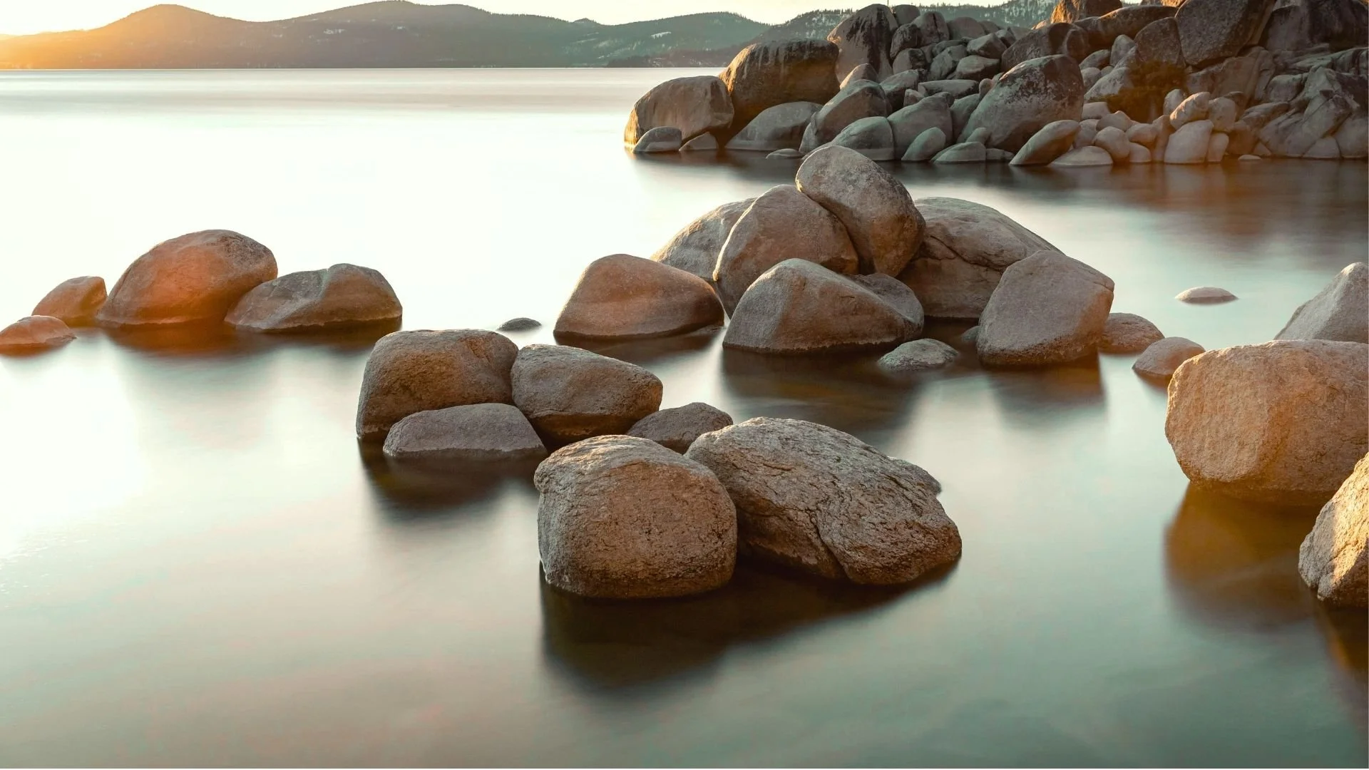 A lake with large rocks representing healing wounds in therapy.