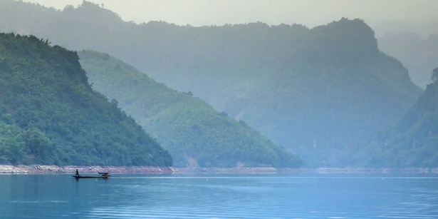 Peaceful green hills and a turquoise lake symbolize stress relief and reconnecting with values, echoing the positive experience described in the review about finding a safe space for growth and managing burnout as a female executive.