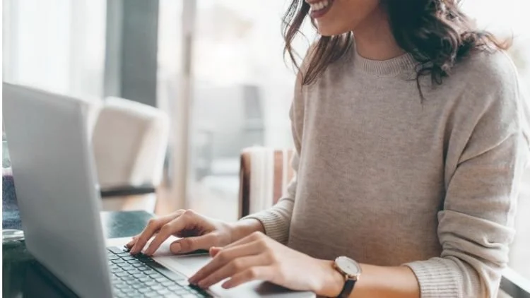 Woman using a laptop for an online therapy session at home