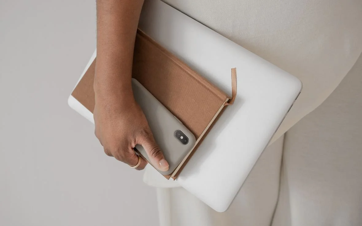 -   - Woman carrying a laptop and notebook
