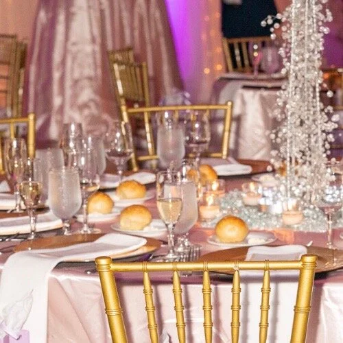 Gold chairs around table with white table cloth, white napkins.jpeg