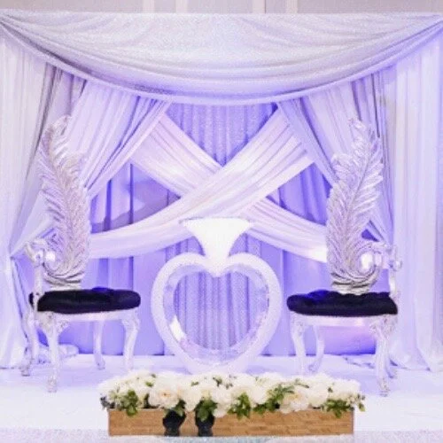 Six chairs on a white platform with hear in the middle and purple lighting.jpeg