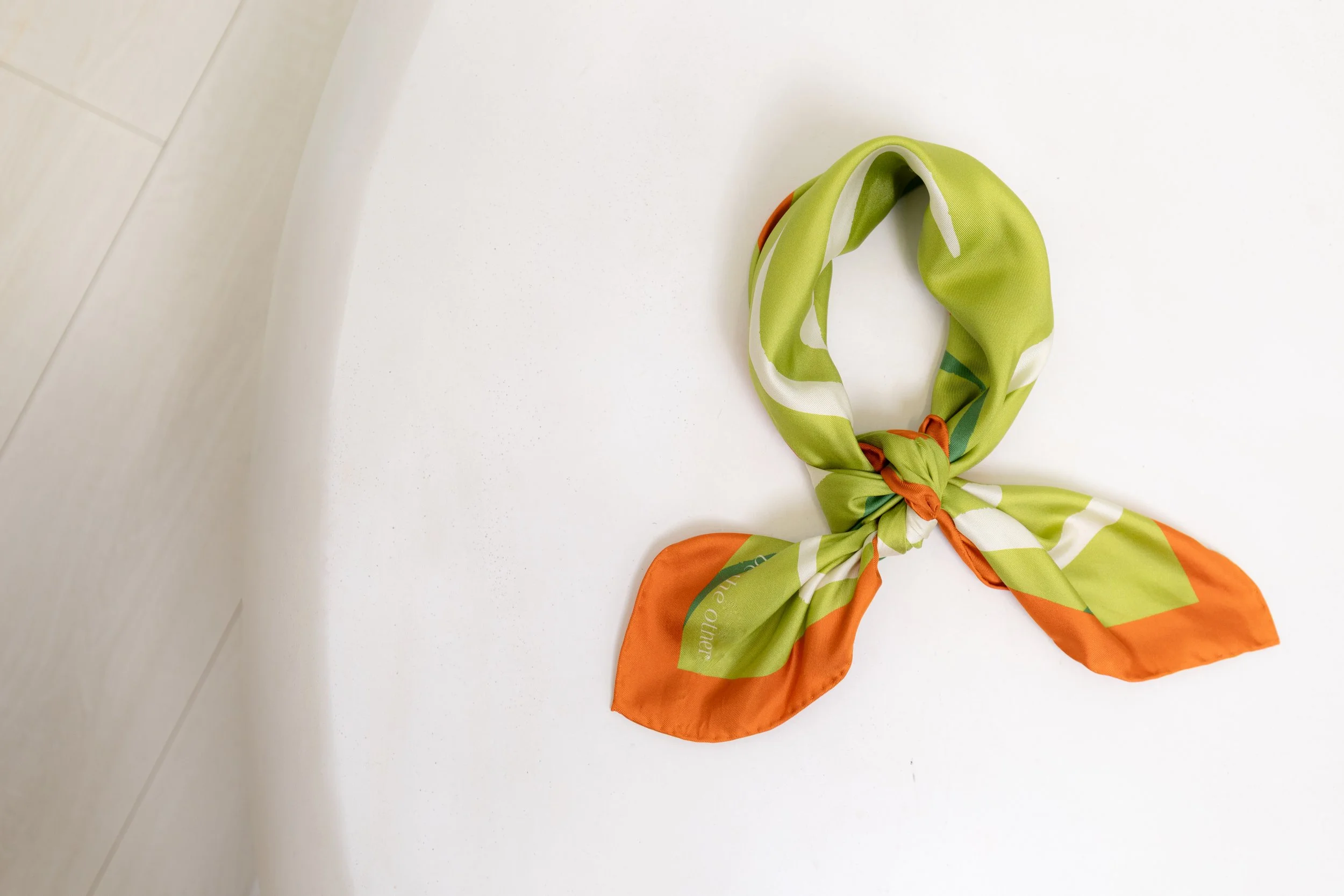 Be The Other birds eye view of a tied, green silk scarf