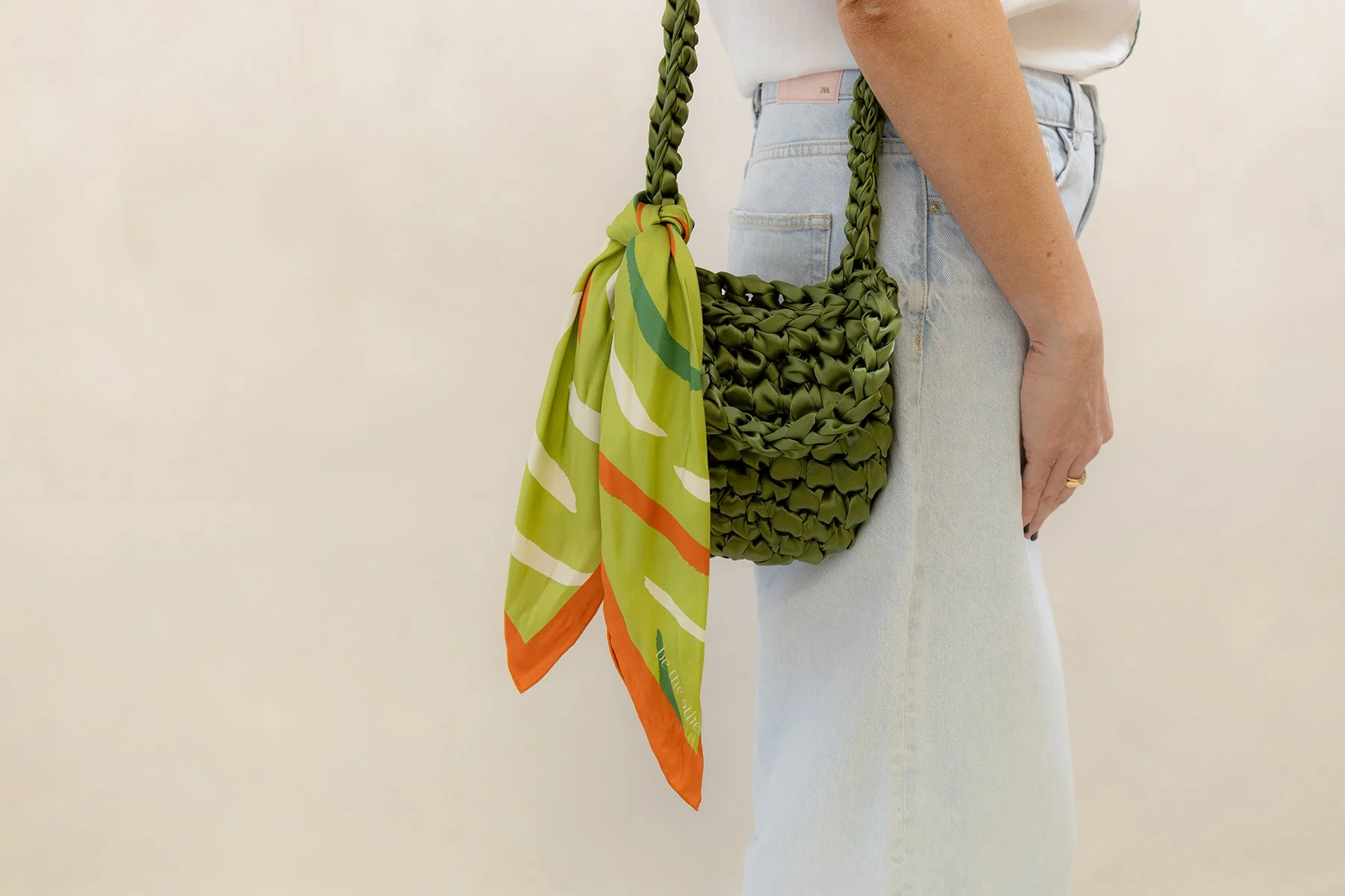 Be The Other  green silk scarf tied to the back of a deep green bag
