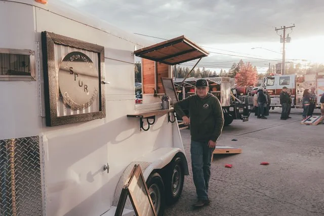 Spur Coffee owner beside the business’s converted coffee trailer