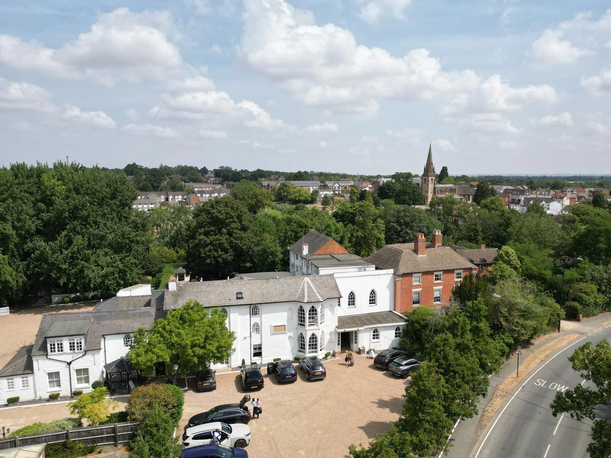 Aerial view of Warwick House wedding venue in Southam, Warwickshire, with the town and church spire behind