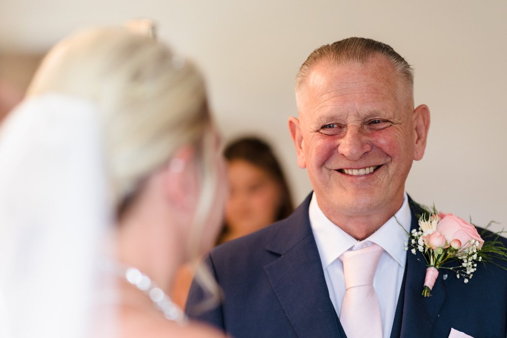 Father of bride smiling during wedding preparations at Hogarths Stone Manor, documentary wedding photography
