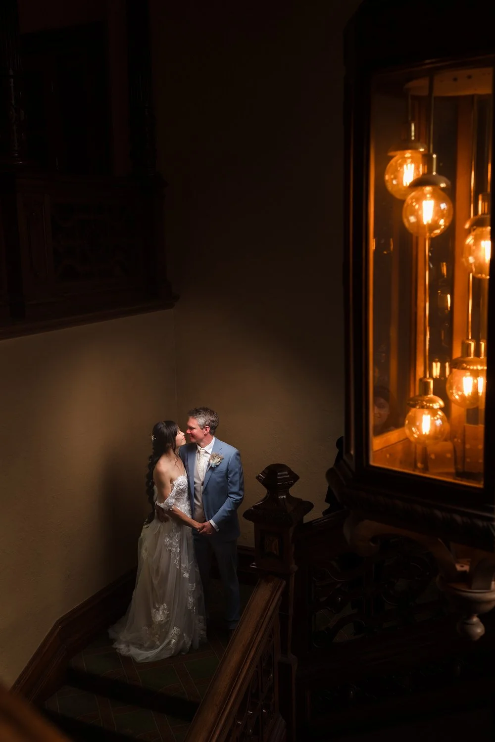 Christine and Greg sharing a quiet moment on The Welcombe Hotel's staircase during evening portraits.