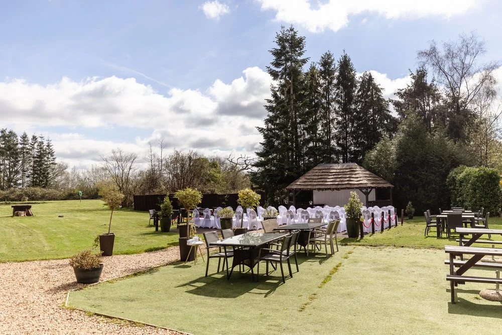 Garden path at The Limes Country Lodge leading to thatched gazebo and tipi with lake visible in background — wedding photography by Once in a Lifetime Photography