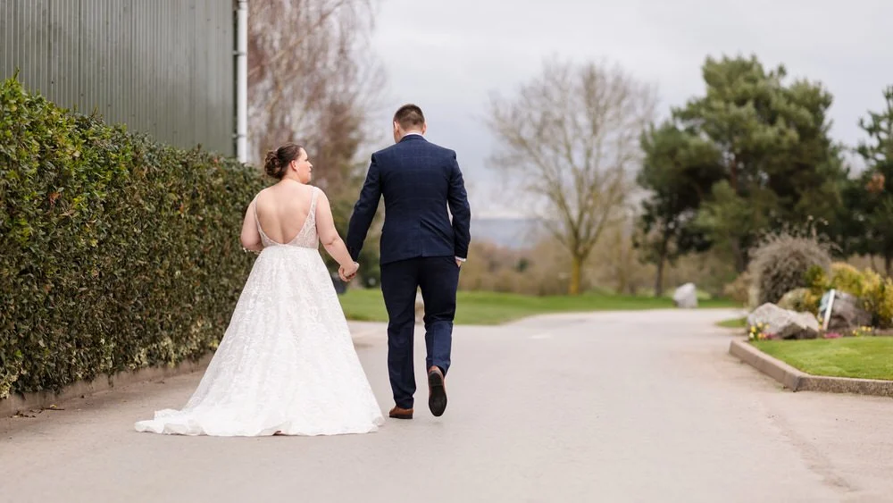 bride and groom walking hand in hand at a wedding