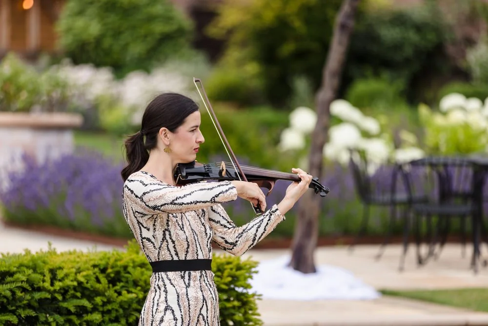 Violinist performing in the gardens at Rowton Castle during the wedding ceremony