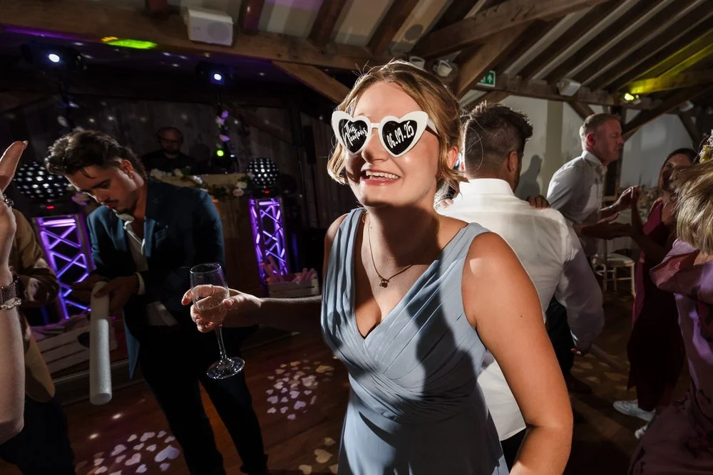 Candid bridesmaid moment at Bredenbury Court Oak Barn wedding reception in Herefordshire