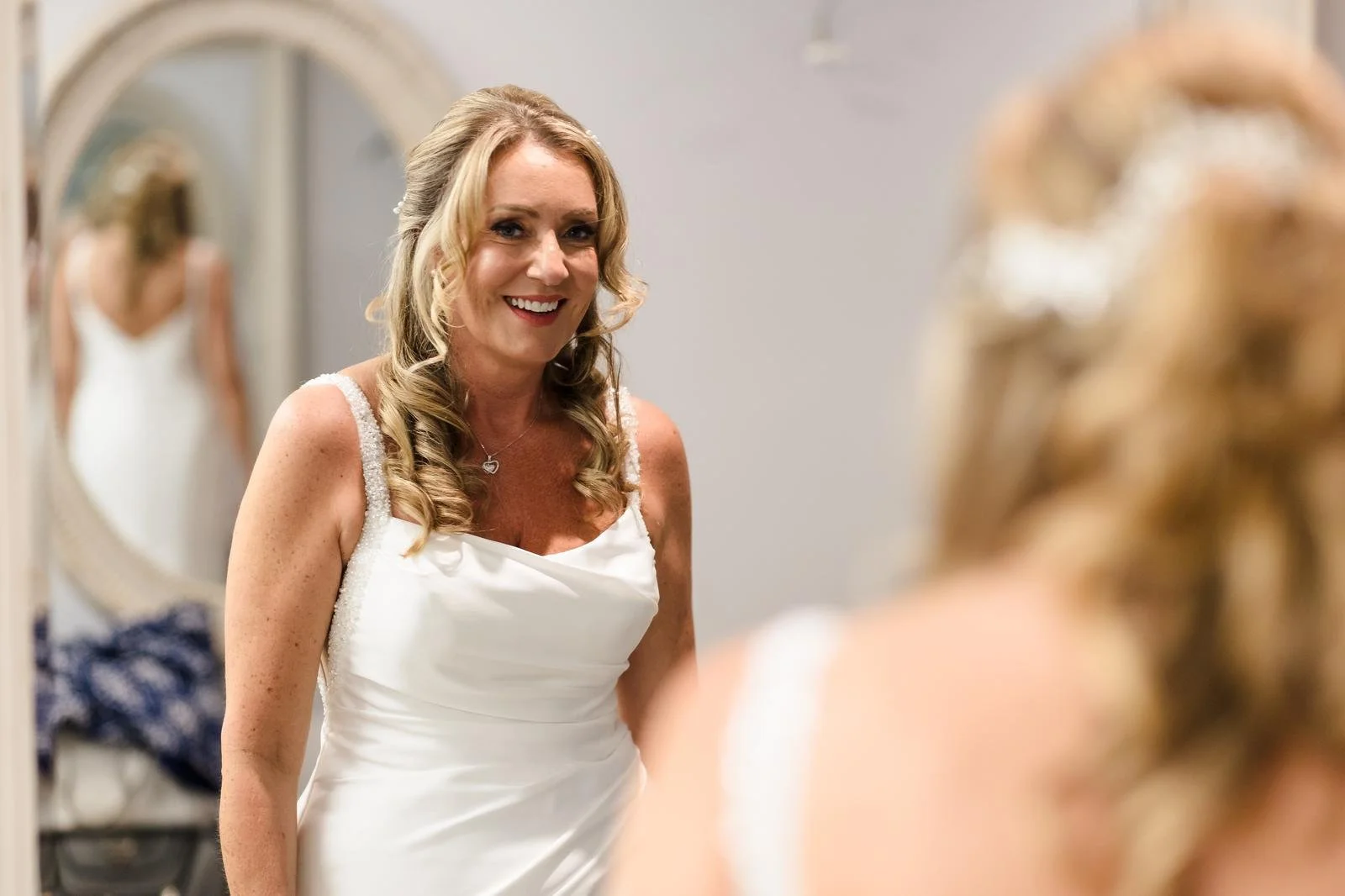 Bride having her hair styled in the mirror before her wedding at Ashton Lodge Country House wedding photography by Once in a Lifetime Photography