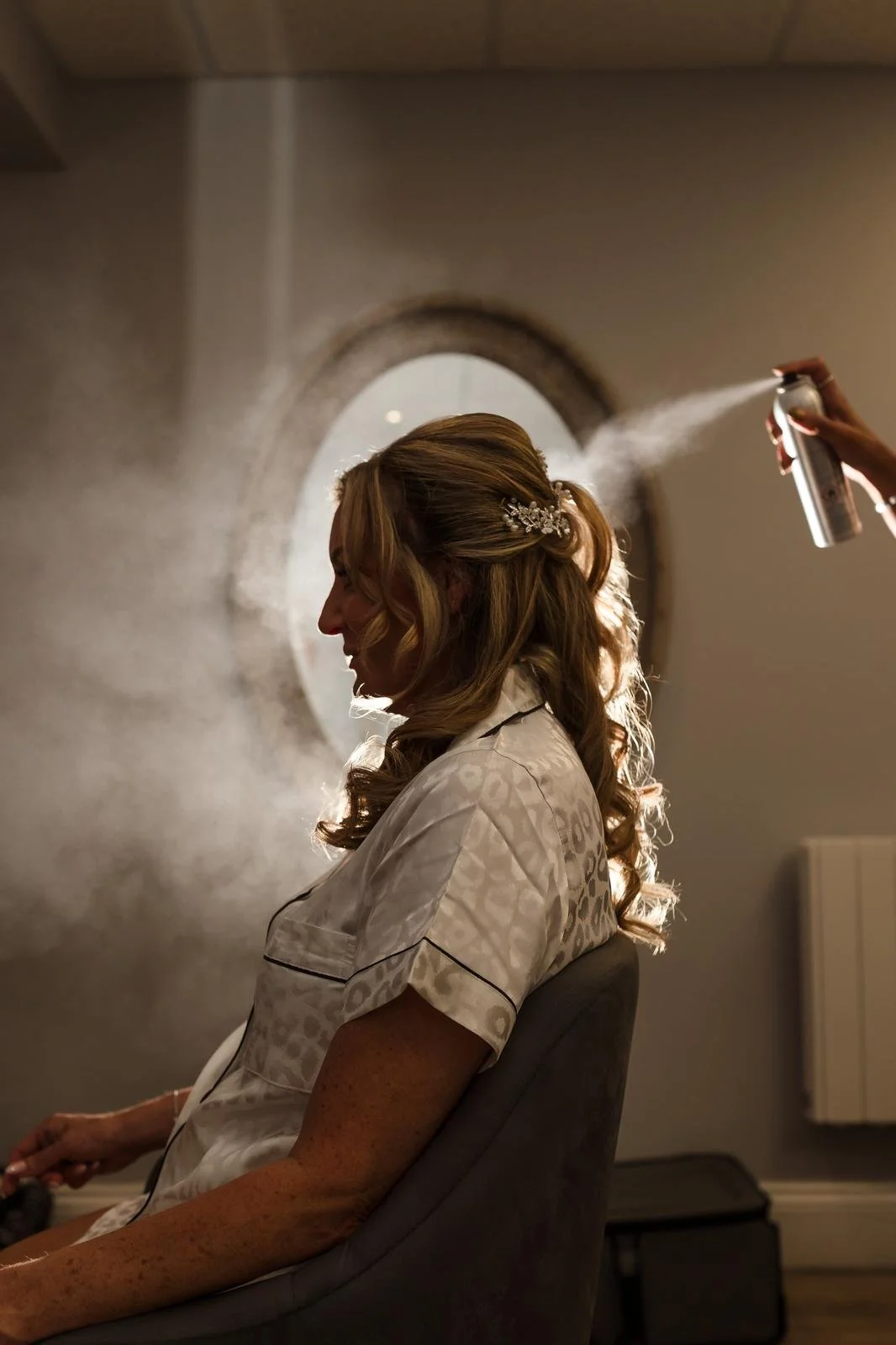 Bride's hairspray moment lit with off-camera flash during wedding morning preparations at Ashton Lodge Country House by Once in a Lifetime Photography