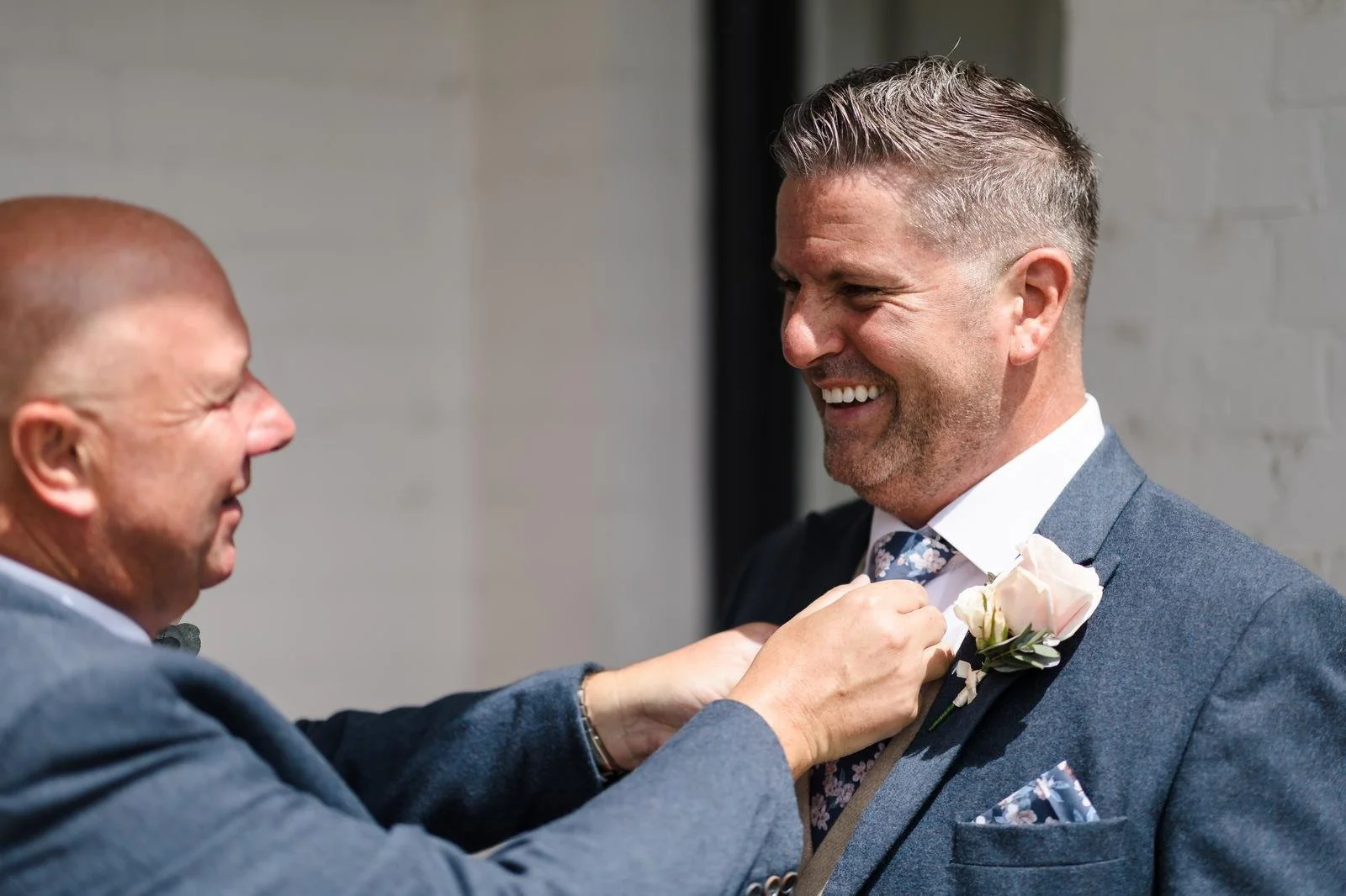 Groom having his buttonhole fitted before the wedding at Ashton Lodge Country House wedding photography by Once in a Lifetime Photography