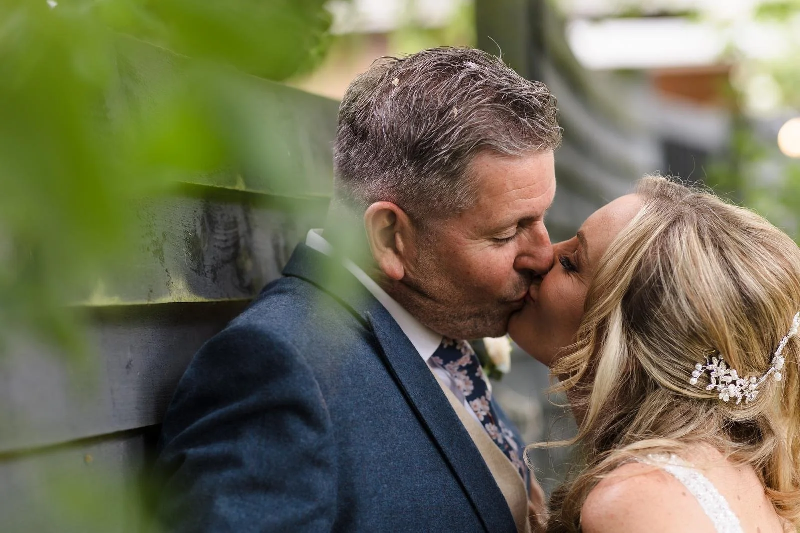 Charlotte and Richard kissing in the garden at Ashton Lodge Country House wedding photography by Once in a Lifetime Photography