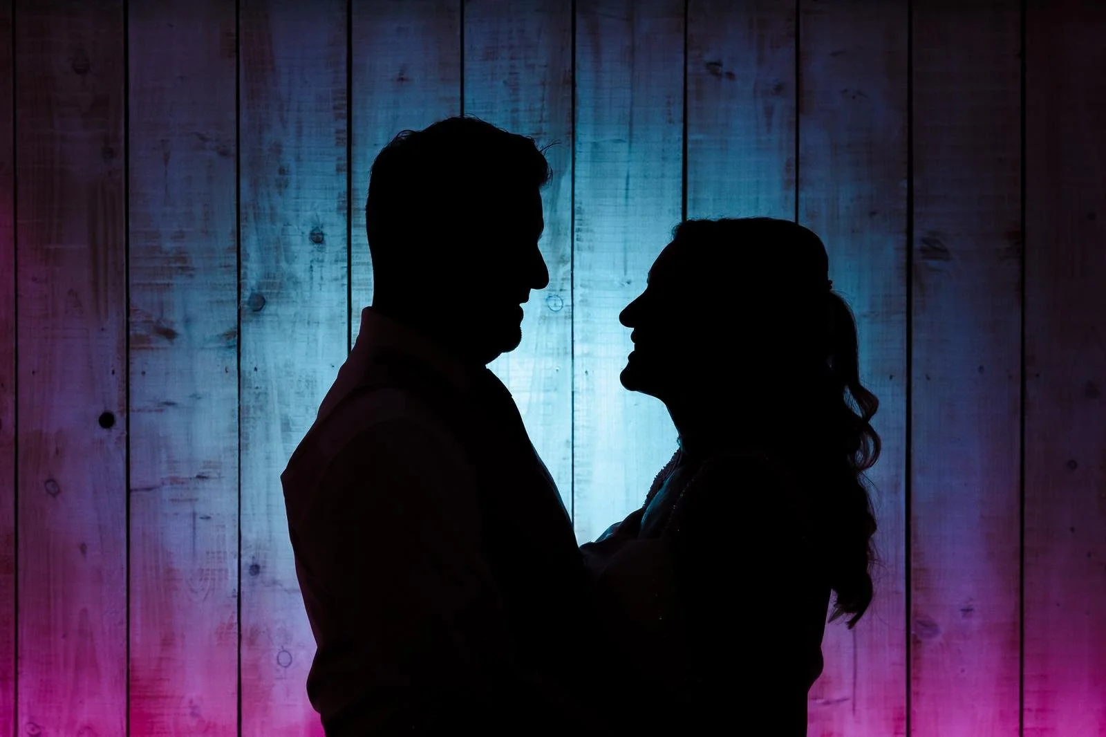 Silhouette couple portrait against coloured gel lighting at Ashton Lodge Country House wedding photography by Once in a Lifetime Photography
