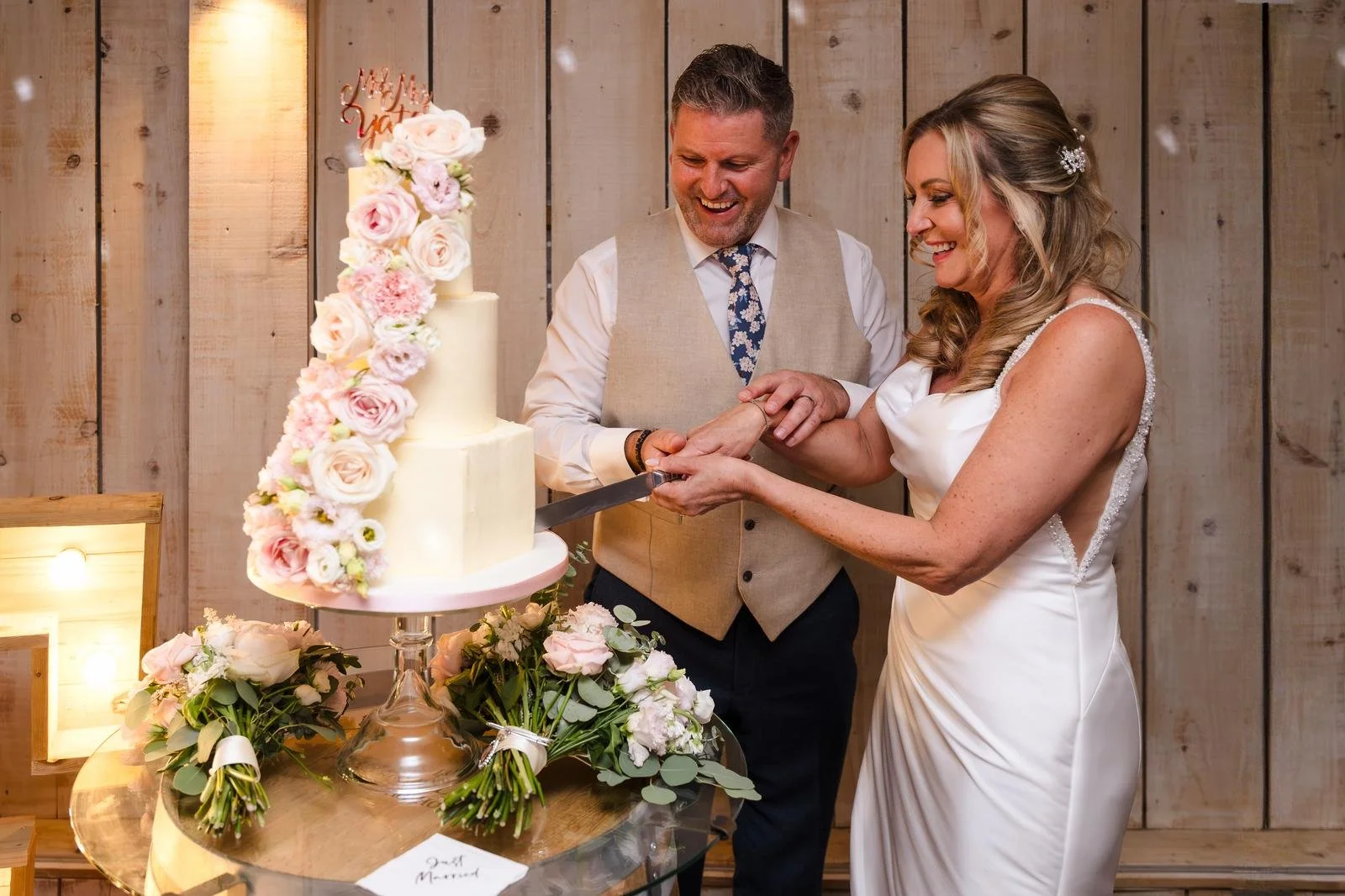 Bride and groom cutting their wedding cake in the marquee at Ashton Lodge Country House wedding photography by Once in a Lifetime Photography