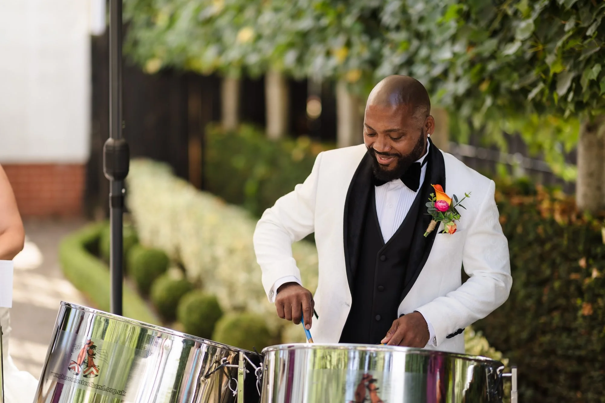 Groom Tafarie having a go on the steel pans in the gardens at Warwick House