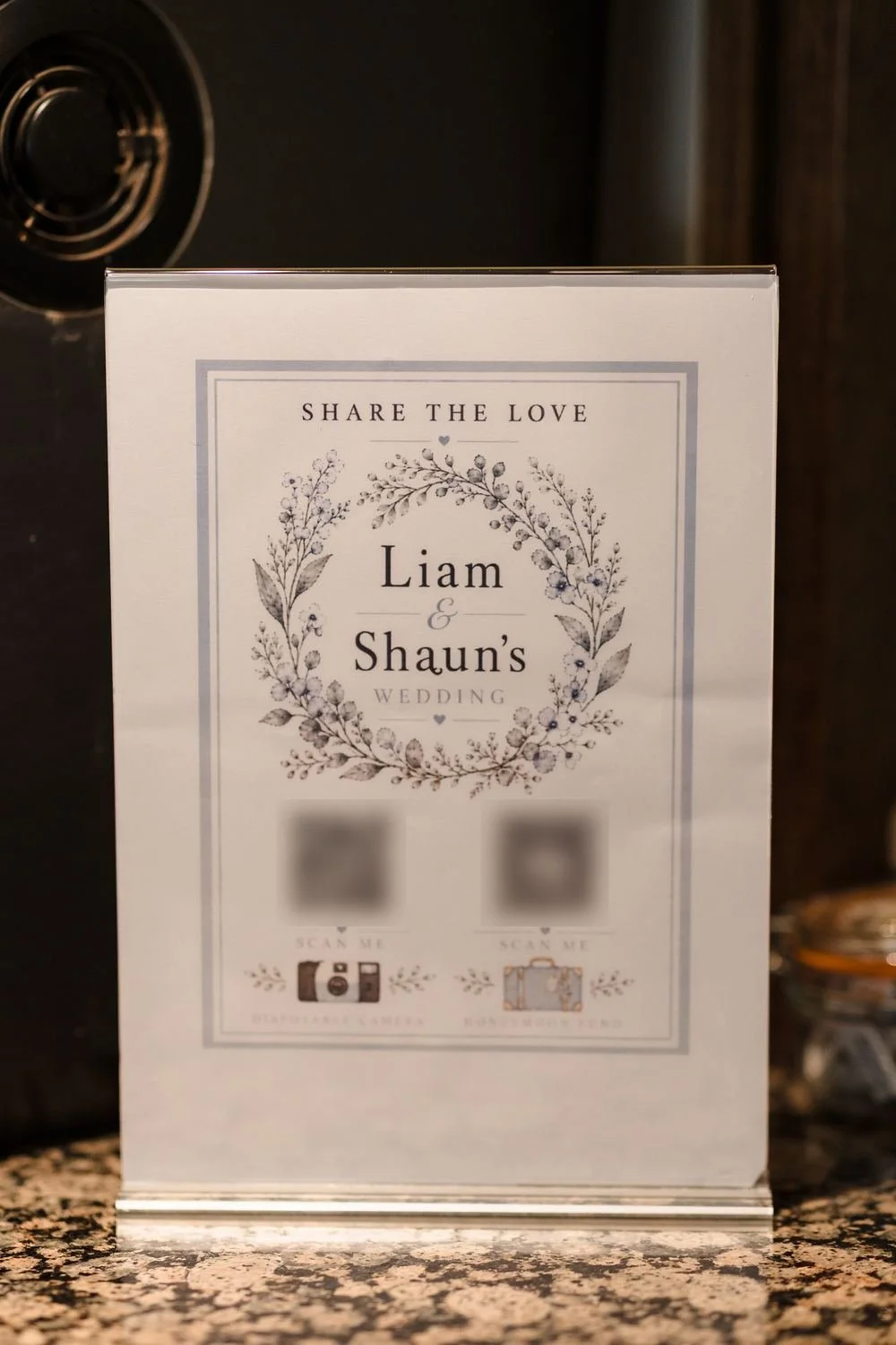 Share the Love table sign for Liam and Shaun's wedding with a pale blue floral wreath design